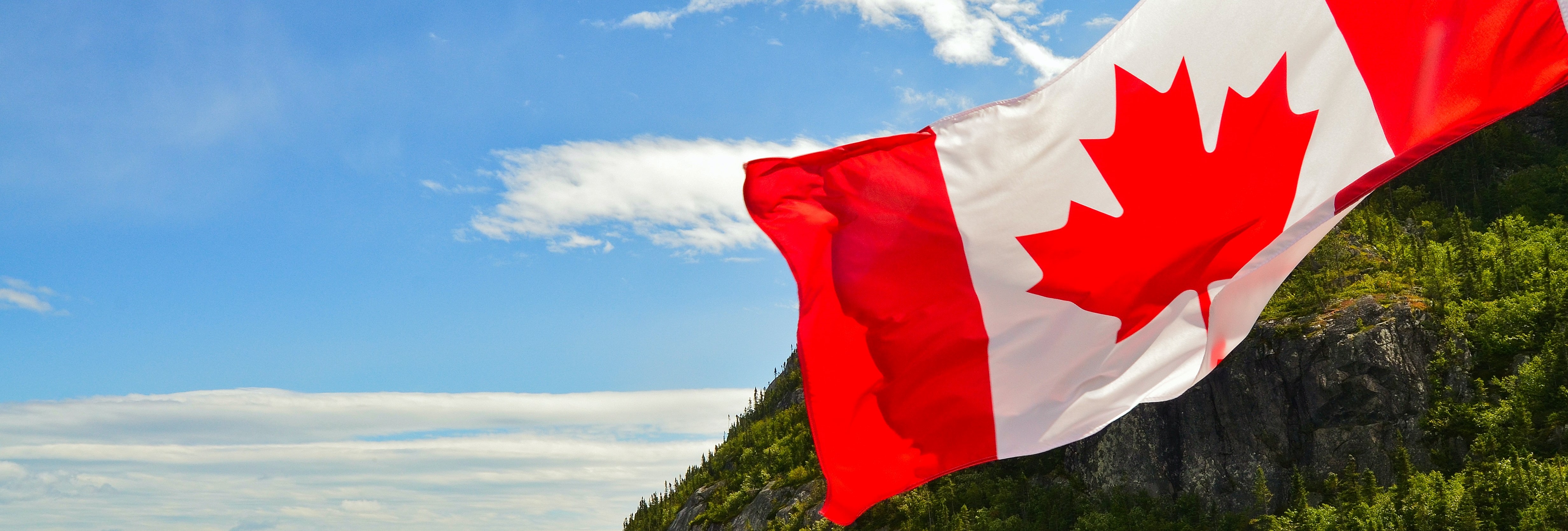 Canadian flag in front of blue sky