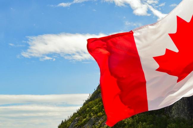 Canadian flag in front of blue sky