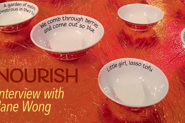 white bowls with words inscribed on a red tablecloth
