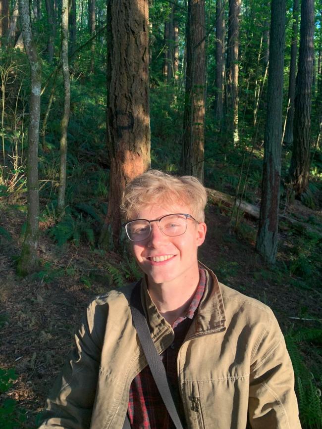 Leif Salveston in a khaki colored jacket in the woods