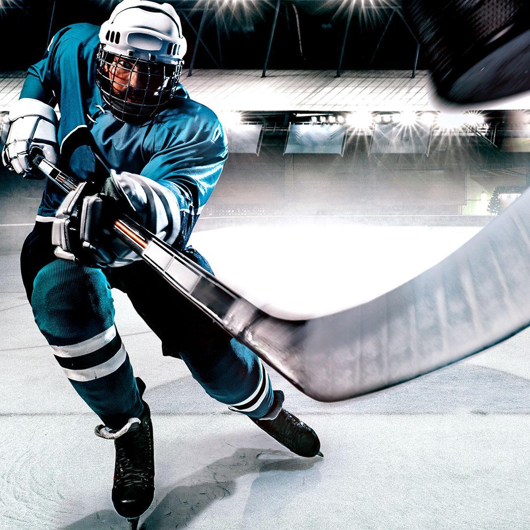 hockey player with stick pointed at camera